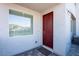 Home entrance with a red front door, window, welcome mat, and exterior lighting at 31 Newport Edge Pl, Henderson, NV 89015