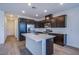 Modern kitchen with stainless steel appliances, dark cabinets, and a quartz island countertop at 31 Newport Edge Pl, Henderson, NV 89015