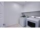 Well-lit laundry room featuring a white washer and dryer set plus ample shelving at 31 Newport Edge Pl, Henderson, NV 89015