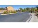 Community entrance featuring a secure gate, landscaping, and well-maintained street at 3429 Glacial Lake St, Las Vegas, NV 89122