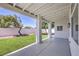 Relaxing covered back patio overlooks a manicured lawn with vibrant green grass and decorative shrubbery at 3693 Miguels Ln, Las Vegas, NV 89120