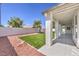 Covered back patio overlooks landscaped yard featuring manicured lawn, decorative rock, and mature shade trees at 3693 Miguels Ln, Las Vegas, NV 89120