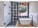 Modern bathroom featuring a glass shower, tub, and decorative accent wall at 3693 Miguels Ln, Las Vegas, NV 89120