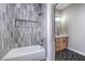 Contemporary bathroom showcasing a tiled shower with tub and a vanity with stylish chevron floor tiles at 3693 Miguels Ln, Las Vegas, NV 89120