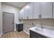 Laundry room featuring white cabinets, countertops, sink, and stainless steel faucet at 3693 Miguels Ln, Las Vegas, NV 89120