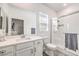 A clean bathroom with single sink vanity, shower with glass doors and bright window at 3821 Nesting Wren Dr, North Las Vegas, NV 89084