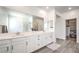 Spa-like bathroom with double sinks, quartz counters, and a glass-enclosed shower, plus walk-in closet at 3821 Nesting Wren Dr, North Las Vegas, NV 89084