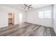 A bright bedroom featuring a large closet and wood-look flooring and a ceiling fan at 3821 Nesting Wren Dr, North Las Vegas, NV 89084