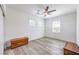 Bright bedroom with modern ceiling fan, wood-look flooring, and natural light from two windows at 3821 Nesting Wren Dr, North Las Vegas, NV 89084