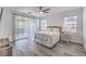 Bright main bedroom featuring wood floors, a ceiling fan, and large windows with natural light at 3821 Nesting Wren Dr, North Las Vegas, NV 89084