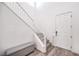 Inviting entryway with a staircase, gray wood flooring, white wall paint, and a storage bench at 3821 Nesting Wren Dr, North Las Vegas, NV 89084