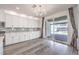 Bright kitchen featuring white cabinets, gray backsplash, stainless steel appliances, and gray wood flooring at 3821 Nesting Wren Dr, North Las Vegas, NV 89084