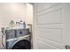 A modern laundry room features a front load washer and dryer with white walls and white door at 3821 Nesting Wren Dr, North Las Vegas, NV 89084