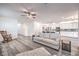 Open living room with lots of space and natural light. A ceiling fan and gray wood flooring add a touch of elegance at 3821 Nesting Wren Dr, North Las Vegas, NV 89084