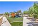 Community playground features colorful play structures, slides, artificial turf and shaded seating, perfect for outdoor fun and relaxation at 3821 Nesting Wren Dr, North Las Vegas, NV 89084