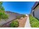 View of landscaped backyard with desert plants, rocks, and block wall at 454 Intrepid Ct, Boulder City, NV 89005