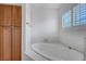 Bathroom features a soaking tub, tiled walls, and wooden cabinet at 454 Intrepid Ct, Boulder City, NV 89005