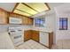 Functional kitchen with ample cabinet space, white appliances, and a tile backsplash at 454 Intrepid Ct, Boulder City, NV 89005