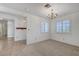 Comfortable living room featuring a chandelier, neutral carpeting, and bright shuttered windows at 454 Intrepid Ct, Boulder City, NV 89005