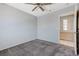 Carpeted bedroom with ceiling fan, next to an ensuite bathroom with tiled floors and cabinets at 4724 Victoria Beach Way, Las Vegas, NV 89130
