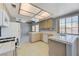Bright kitchen featuring tile countertops, wood cabinets, tile floors, and stainless steel appliances at 4724 Victoria Beach Way, Las Vegas, NV 89130