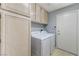 Spacious laundry room with cabinets, washer, dryer, and access to the backyard at 4724 Victoria Beach Way, Las Vegas, NV 89130