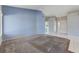 Spacious living room with plush carpet and ample natural light, leading to the laundry area at 4724 Victoria Beach Way, Las Vegas, NV 89130