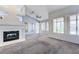 Bright living room featuring a fireplace, neutral carpet, and a wall of sunny windows at 4724 Victoria Beach Way, Las Vegas, NV 89130