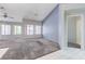 Spacious living room with plush carpet, large windows, and neutral paint at 4724 Victoria Beach Way, Las Vegas, NV 89130