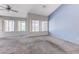 Bright living room featuring plush carpet, large windows, and neutral paint at 4724 Victoria Beach Way, Las Vegas, NV 89130