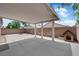 Large covered back patio with brick privacy wall, concrete pad, and outdoor dog house at 5001 Morning Falls Ave, Las Vegas, NV 89131