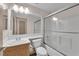 Well-lit bathroom features an oak-stained vanity and a shower-over-tub with a sliding glass door at 5001 Morning Falls Ave, Las Vegas, NV 89131