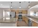 Stylish kitchen featuring stainless steel appliances, wood cabinets, and an island with granite countertops overlooking the dining area at 5001 Morning Falls Ave, Las Vegas, NV 89131