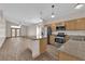 Bright kitchen featuring an island, stainless steel appliances, wood cabinets, and open layout to the living area at 5001 Morning Falls Ave, Las Vegas, NV 89131