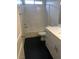Clean bathroom featuring a tiled shower-tub, dark tile floors, and a white cabinet with a solid surface at 5414 Enchanted Rose St, Las Vegas, NV 89148