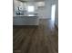 Open kitchen featuring an island, stainless steel appliances, white cabinets, and wood-look floors at 5414 Enchanted Rose St, Las Vegas, NV 89148