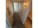 Narrow hallway featuring gray carpet, modern lighting and access to an adjacent bathroom at 5710 E Tropicana Ave # 2225, Las Vegas, NV 89122