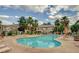 Beautiful community pool area features lounge chairs, palm trees, and clear blue skies at 5710 E Tropicana Ave # 2225, Las Vegas, NV 89122