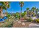 Lush backyard featuring desert landscaping, palm trees, and patio seating area with a shade canopy at 5805 Cabo San Lucas Ave, Las Vegas, NV 89131