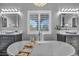 Well-lit bathroom featuring a freestanding tub, dual vanities, and plantation shutters at 5805 Cabo San Lucas Ave, Las Vegas, NV 89131
