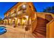 Twilight view of the home's exterior featuring an outdoor staircase and balcony overlooking a well-lit backyard and pool area at 5805 Cabo San Lucas Ave, Las Vegas, NV 89131
