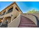 Low angle view of the exterior with an outdoor staircase leading to a covered balcony, showcasing its architecture at 5805 Cabo San Lucas Ave, Las Vegas, NV 89131