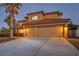 Attractive two-story home featuring an attached two-car garage and a well-lit driveway at 5805 Cabo San Lucas Ave, Las Vegas, NV 89131