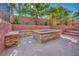 Inviting backyard seating around a stone fire pit, enhanced by lush palm trees for relaxed outdoor living at 5805 Cabo San Lucas Ave, Las Vegas, NV 89131