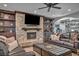 Living room with stone fireplace, wooden mantel, built-in shelves and leather sofas at 5805 Cabo San Lucas Ave, Las Vegas, NV 89131