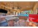 Outdoor kitchen features a pizza oven, grill, bar seating, and covered patio with ceiling fan and TV at 5805 Cabo San Lucas Ave, Las Vegas, NV 89131