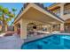 Poolside covered kitchen area with a grill, bar seating, and entertainment area at 5805 Cabo San Lucas Ave, Las Vegas, NV 89131