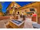 Outdoor living area features a fire pit, kitchen, seating, and TV for ultimate entertainment and relaxation at 5805 Cabo San Lucas Ave, Las Vegas, NV 89131