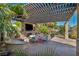 Outdoor living space with shaded seating, a fireplace, and a built-in TV, creating an inviting atmosphere for gatherings at 5805 Cabo San Lucas Ave, Las Vegas, NV 89131