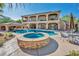 Daytime view of the backyard highlighting the pool, jacuzzi, covered patio bar, and lush tropical landscaping at 5805 Cabo San Lucas Ave, Las Vegas, NV 89131
